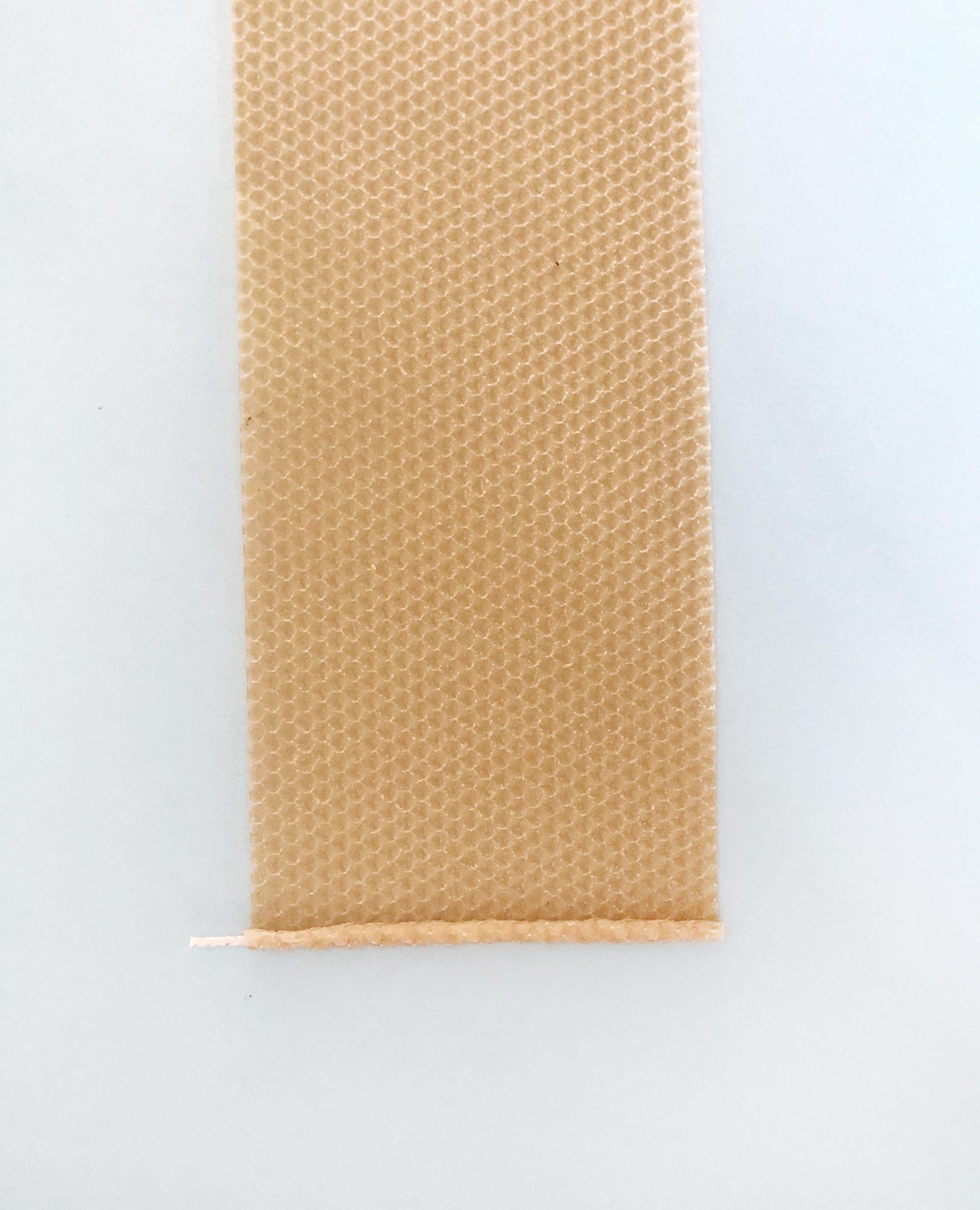 Candle wick partly rolled in beeswax