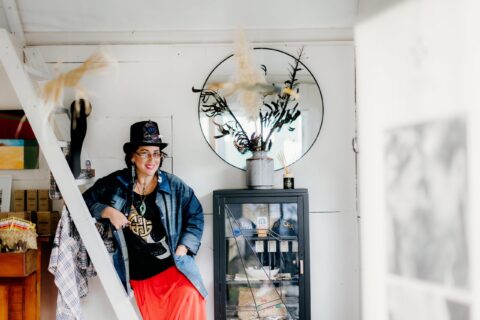 Haley Lowe wearing O Te Motu Creations jewellery, a jean jacket and black hat