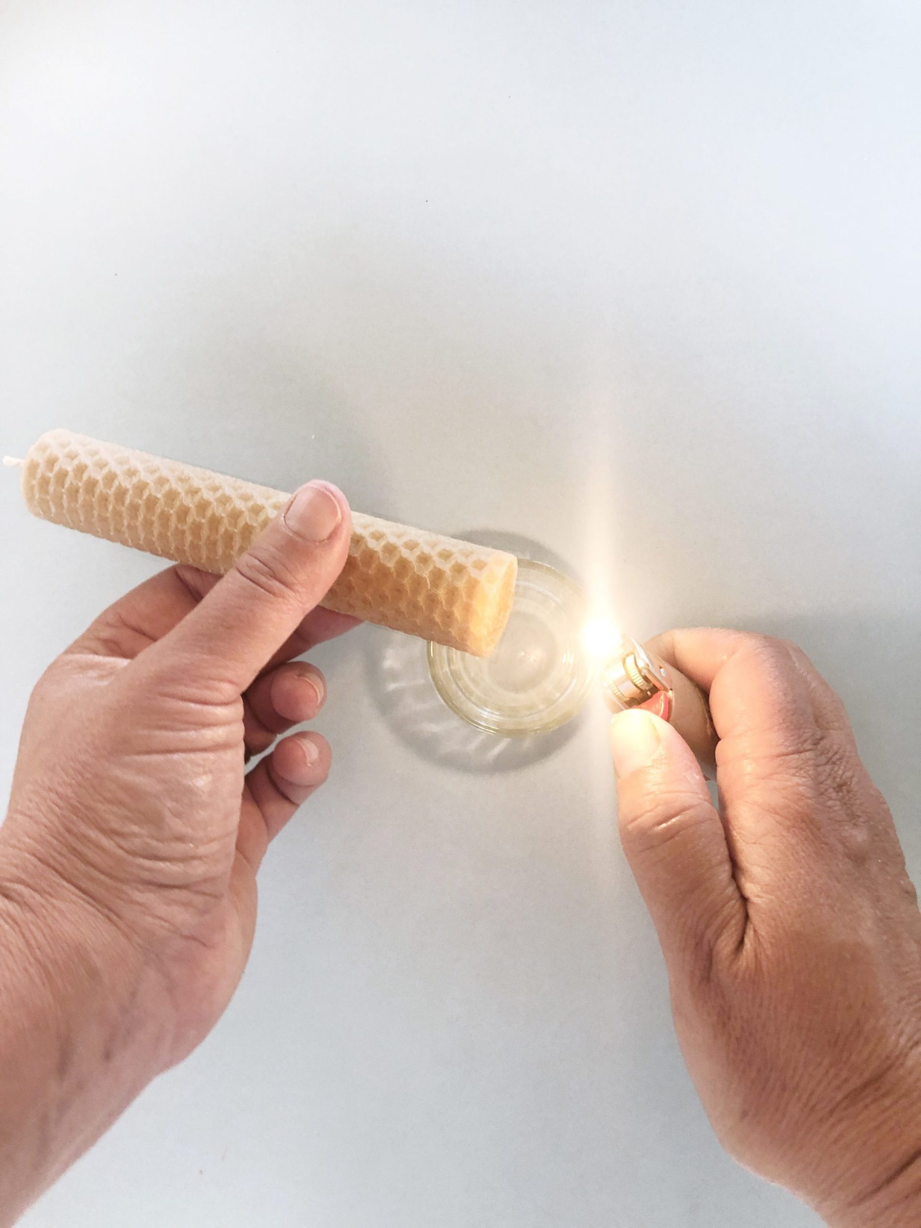 Melting base of bees wax candle with a lighter