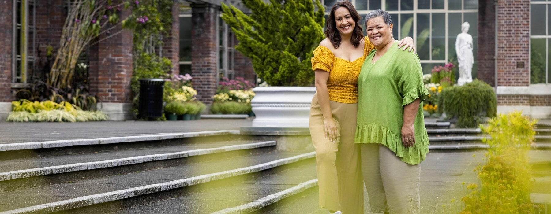 Stacey Leilua with her arms around Ana Tuisila at the Auckland Botanic Gardens