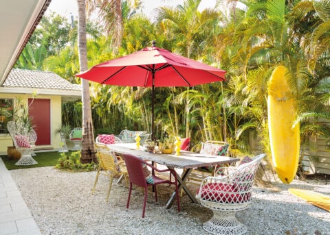 Outside dining area with yellow surfboard and red umbrella