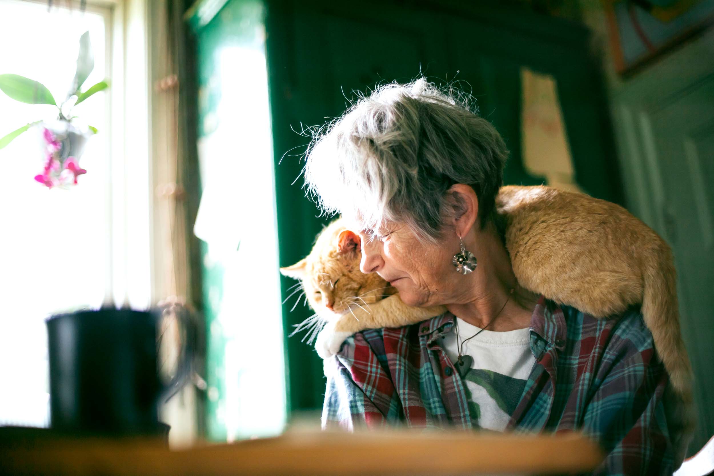 a woman with a ginger cat on her shoulders